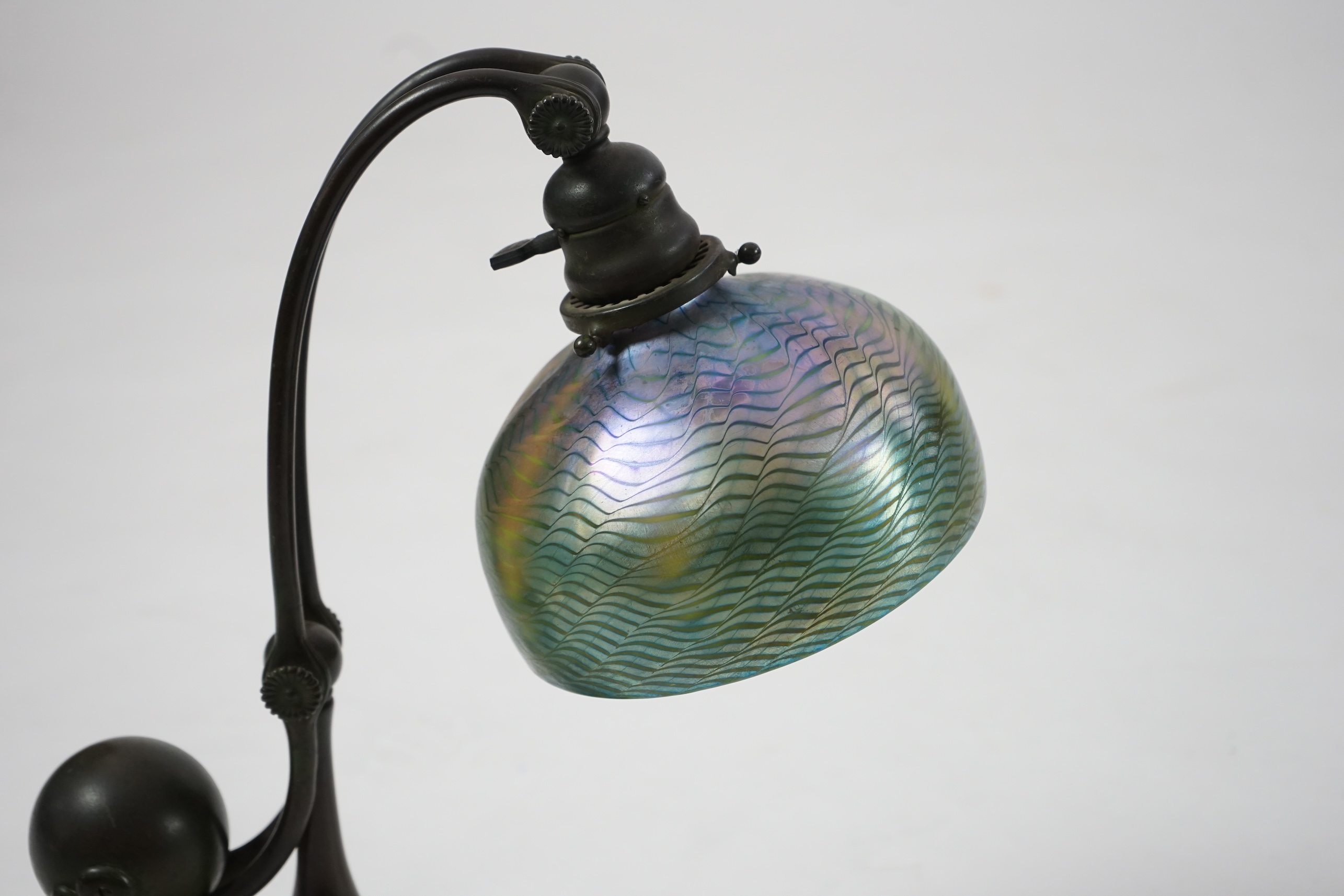 Tiffany Studios. A patinated bronze counter-balance desk lamp with ‘favrile’ glass shade, c.1905